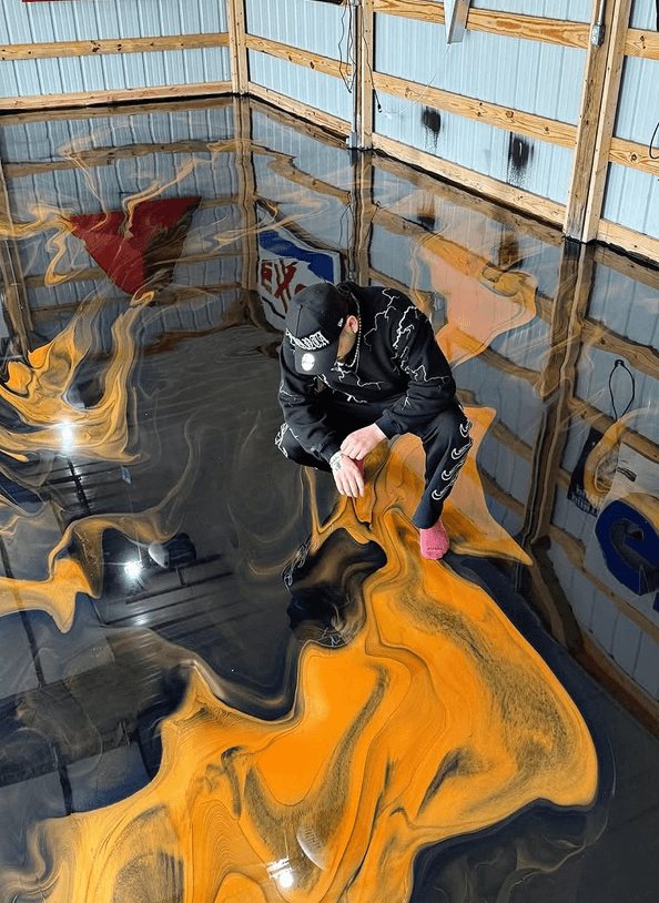 JP Resin working an orange and black metallic epoxy floor, confirmed guest at The Golden Pour Awards 2026